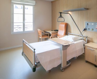 Chambre individuelle avec lit médicalisé coin bureau, télévision, armoire